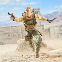 Action figure of a bearded soldier running through a sandy desert with a pistol and knife