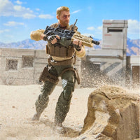 Military action figure running through sand while holding a rifle beside a rocky barrier
