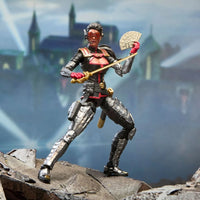 Black and silver costumed action figure holding a staff and fan of cards on a rocky ledge