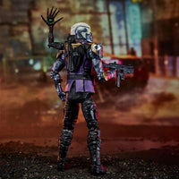 Armored sci fi action figure holding a staff and futuristic blaster in a ruined industrial setting