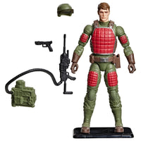 Military-style action figure in green and red armor with helmet, rifle, pistol, radio, and display stand