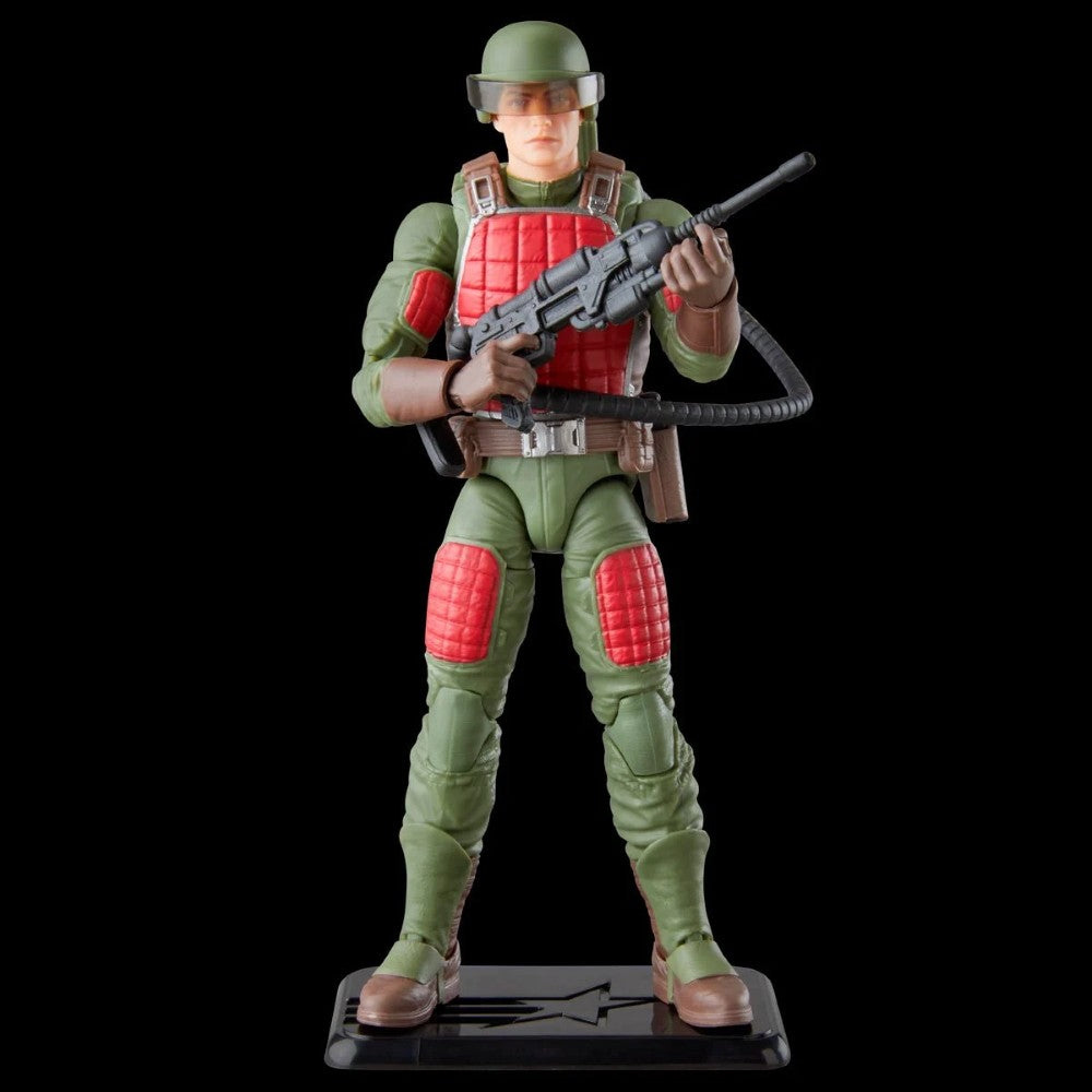 Green and red military action figure holding a rifle on a display stand