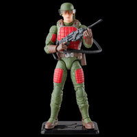 Green and red military action figure holding a rifle on a display stand