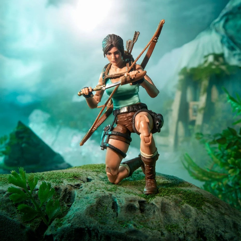 Female adventurer action figure kneeling with a bow on a mossy rock in a lush jungle setting