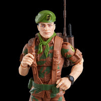 Camouflaged military action figure wearing a green beret, scarf, tactical vest, and backpack with a rifle afield