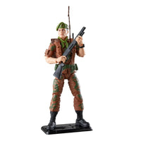 Military action figure in camouflage uniform holding a rifle on a display base