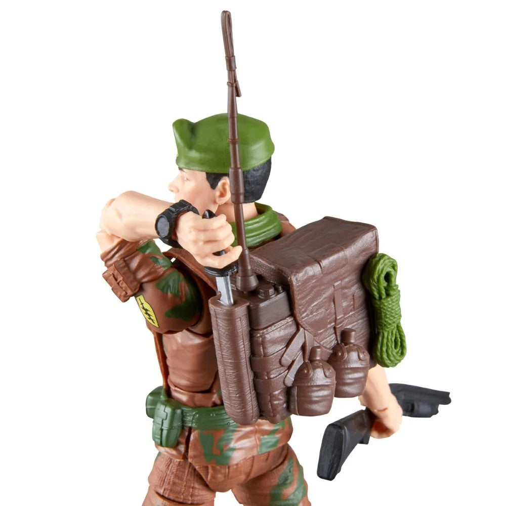 Toy soldier figure wearing a green hat and camouflage clothing with a backpack, bow, and black gun