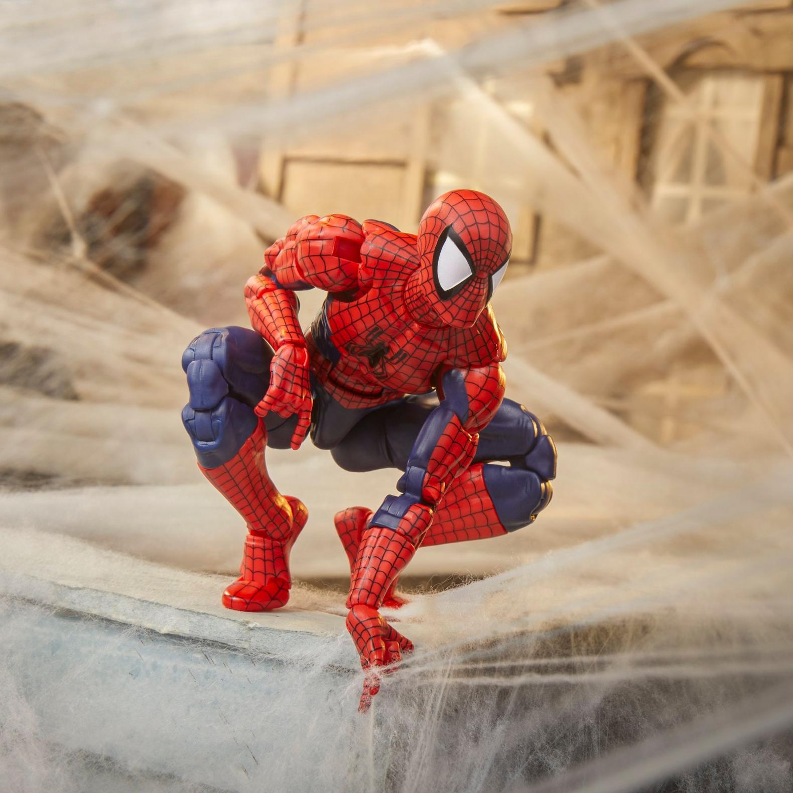 Hasbro Spider-Man action figure in classic red and blue suit posed crouching on a concrete surface with web details.