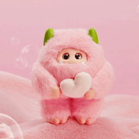 OHKU Giggle Monster Marshmallow Dreams pink fluffy plush with green horns holding a heart-shaped object on soft pink background