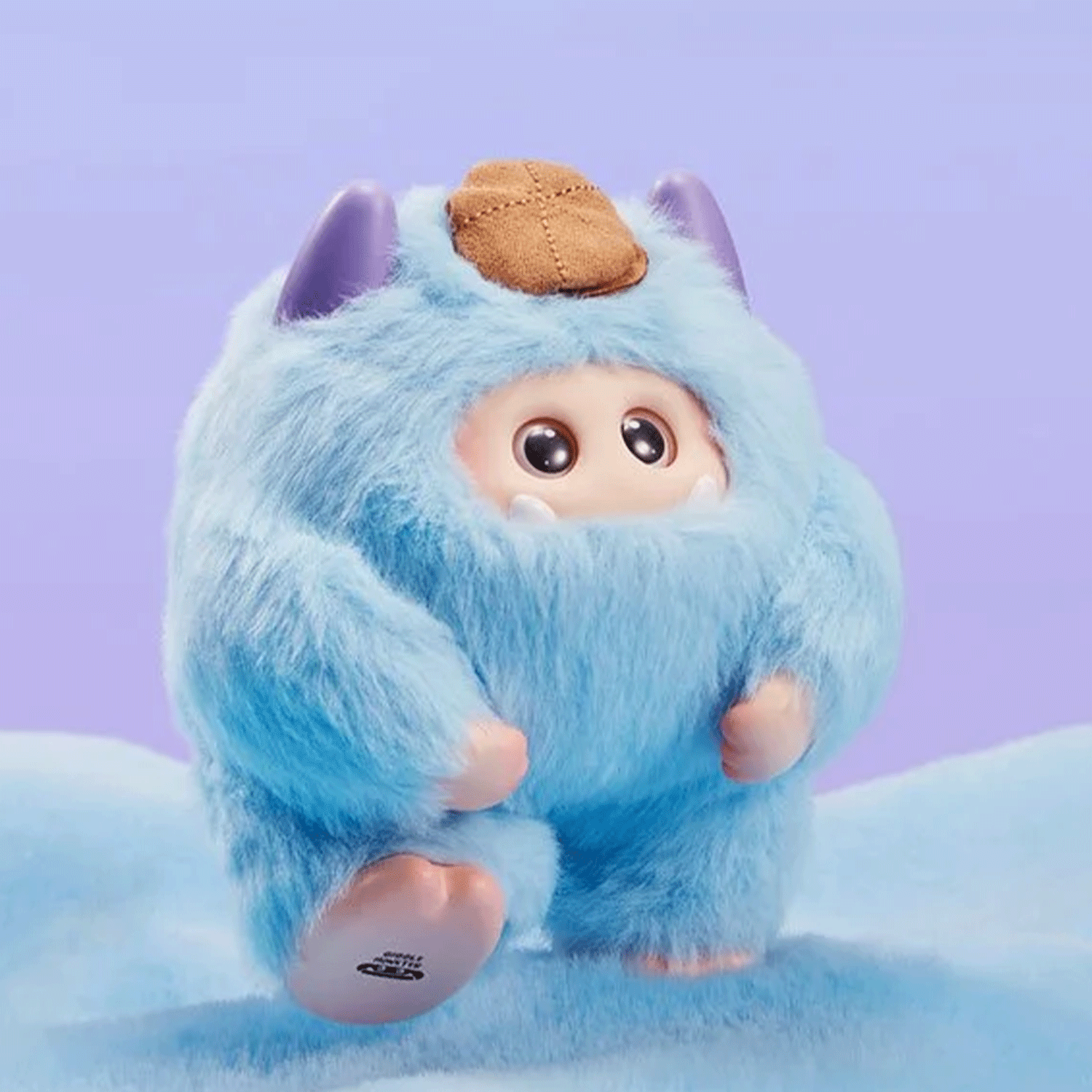 OHKU Giggle Monster Marshmallow Dreams soft blue vinyl plush with hidden eyes and tan hat on pastel purple background