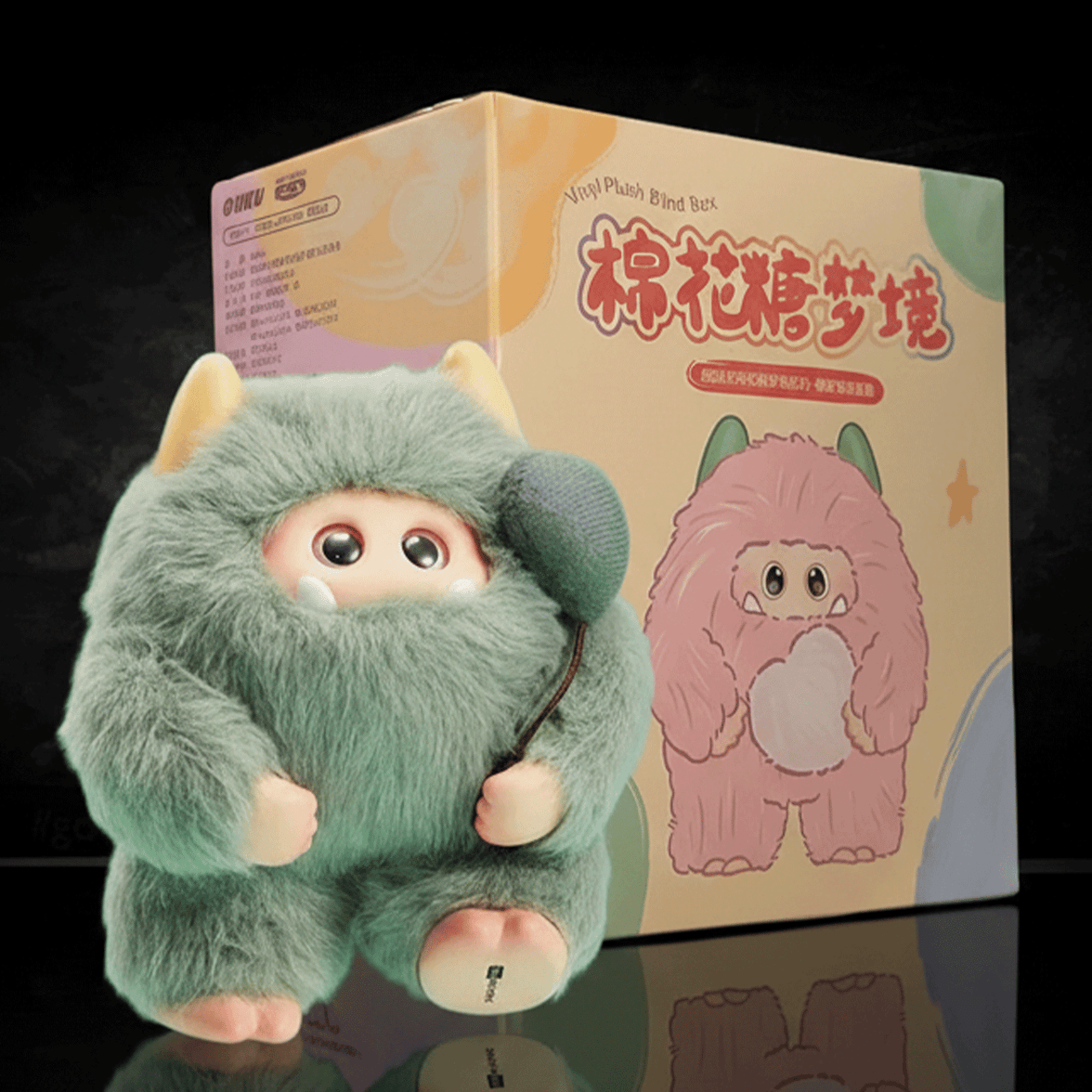 OHKU Giggle Monster Marshmallow Dreams green plush with hidden eyes and soft horns beside illustrated blind-box packaging
