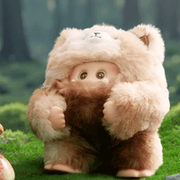 OHKU Giggle Monster vinyl figure in fluffy cream and brown fuzzy creature outfit with big shiny eyes on grassy forest floor