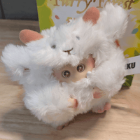 OHKU Giggle Monster vinyl plush in fluffy white creature costume with tiny fangs and sparkling eyes on wooden surface