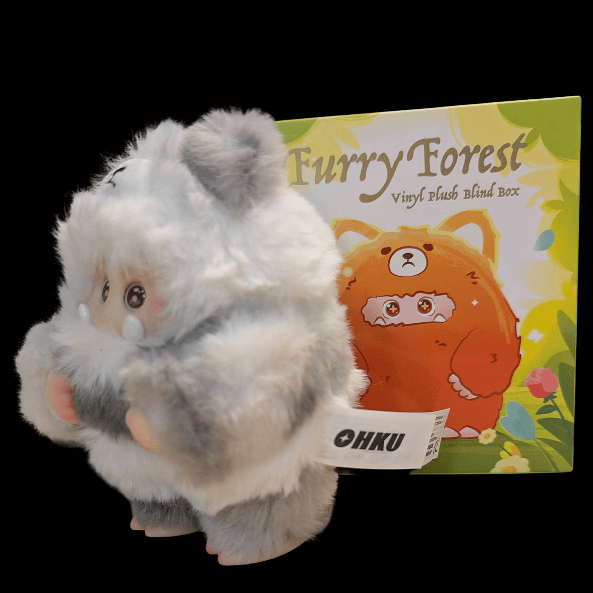 OHKU Giggle Monster plush in fluffy gray and white creature costume with expressive eyes next to Furry Forest blind box packaging