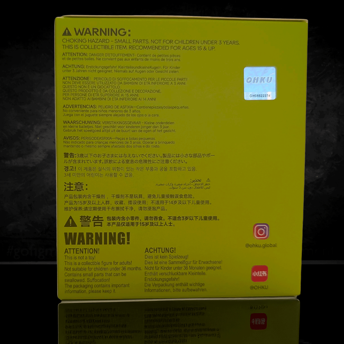 OHKU Giggle Monster blind box packaging with multilingual safety warnings and collector information on yellow background