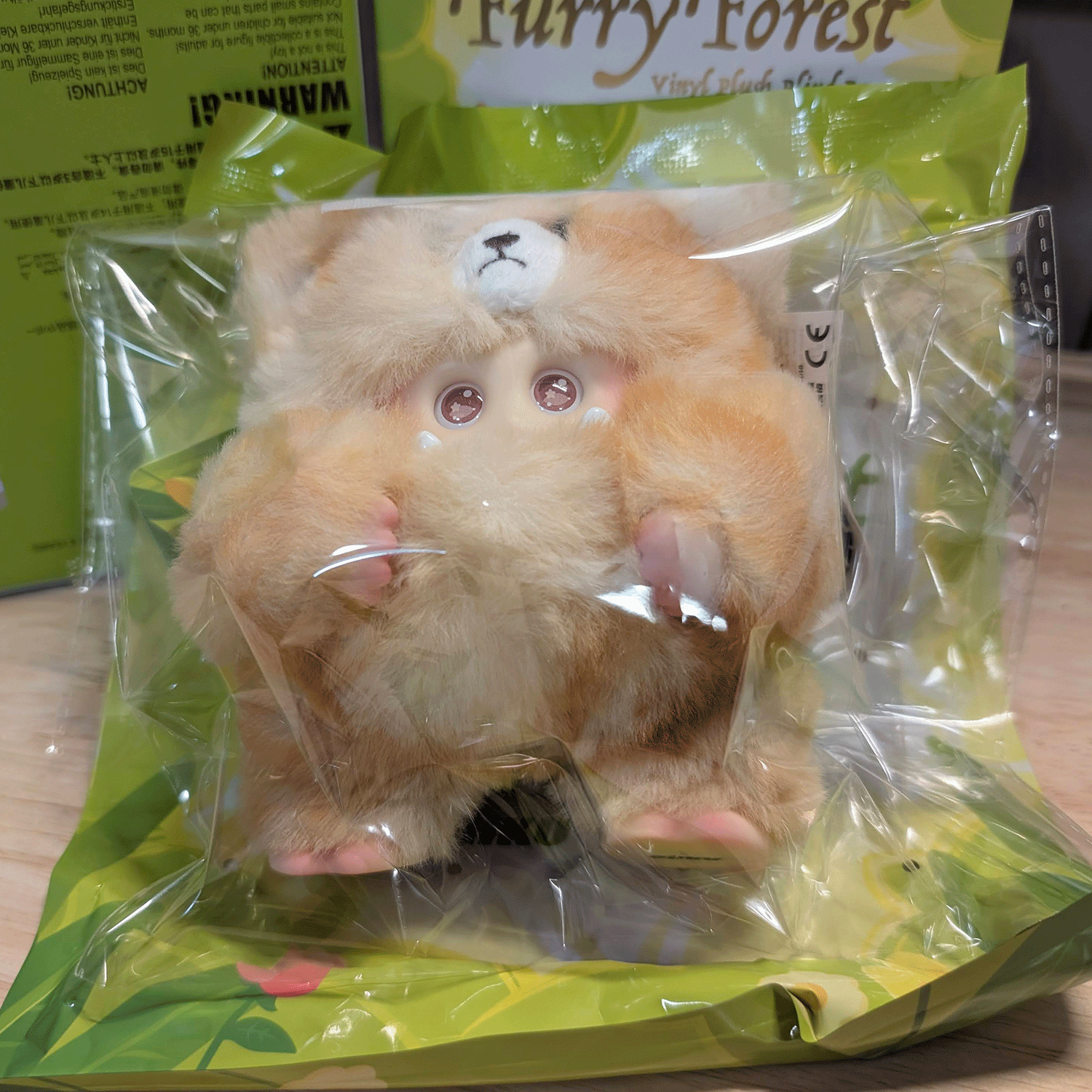 OHKU Giggle Monster vinyl plush in soft tan fluffy creature costume with small claws inside clear packaging