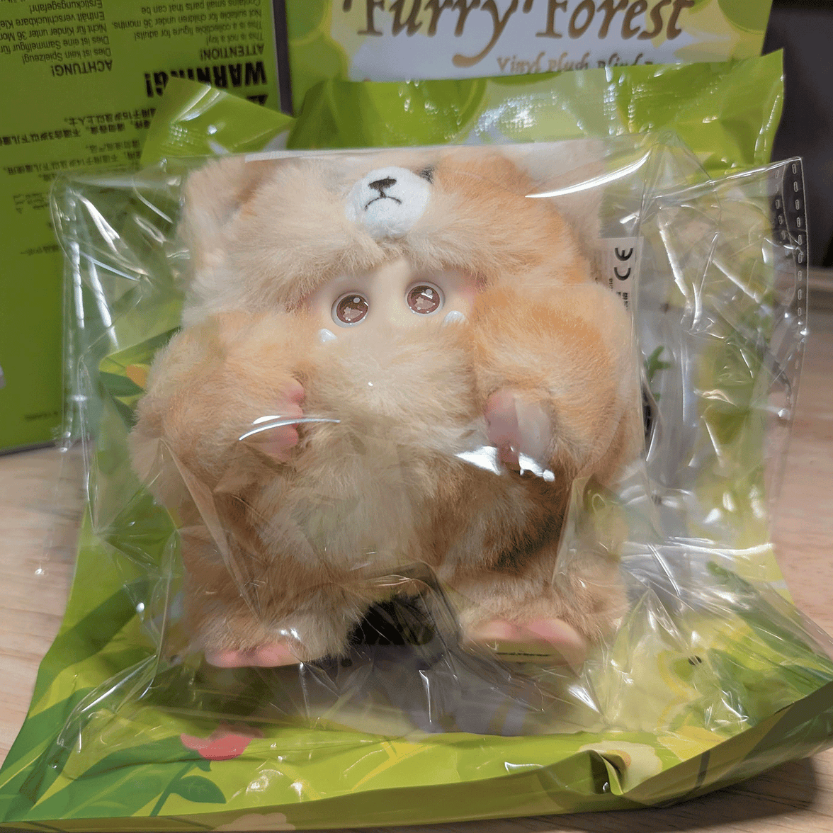 OHKU Giggle Monster vinyl plush in soft tan fluffy creature costume with small claws inside clear packaging