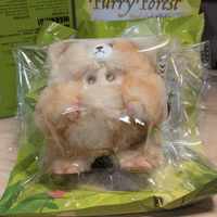 OHKU Giggle Monster vinyl plush in soft tan fluffy creature costume with small claws inside clear packaging