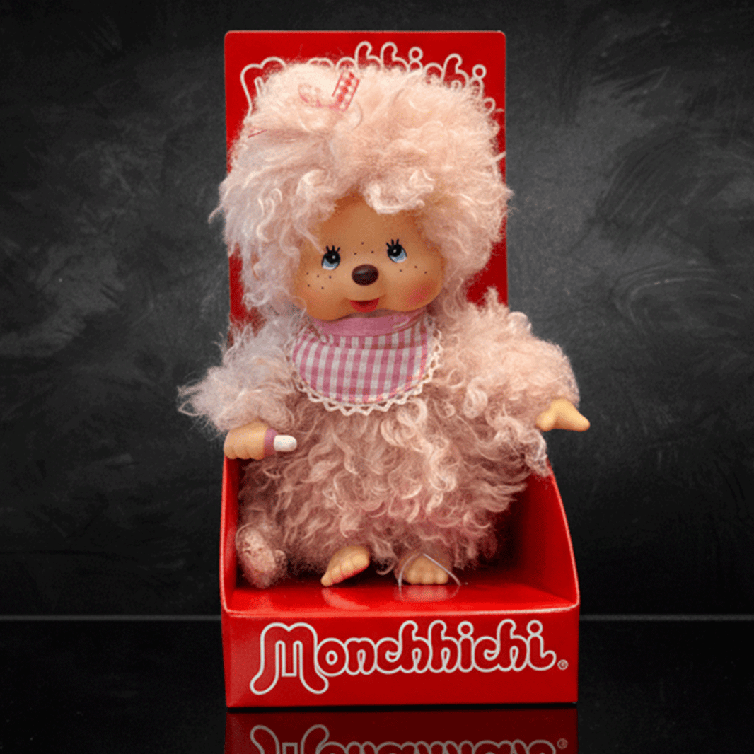 Sekiguchi 8 inch Monchhichi girl doll with fluffy pink beige fur wearing pink gingham bib in red box