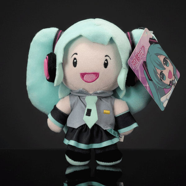 Front view of UCC branded 6-inch Hatsune Miku plush with teal twin tails and detailed outfit on black background
