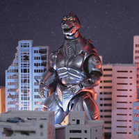 Dark metallic Mechagodzilla figure with illuminated eyes standing amid miniature city buildings at night.