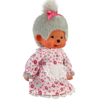 Vintage Monchhichi doll wearing a pink floral dress with lace apron and a gray fur hat tied with a pink ribbon