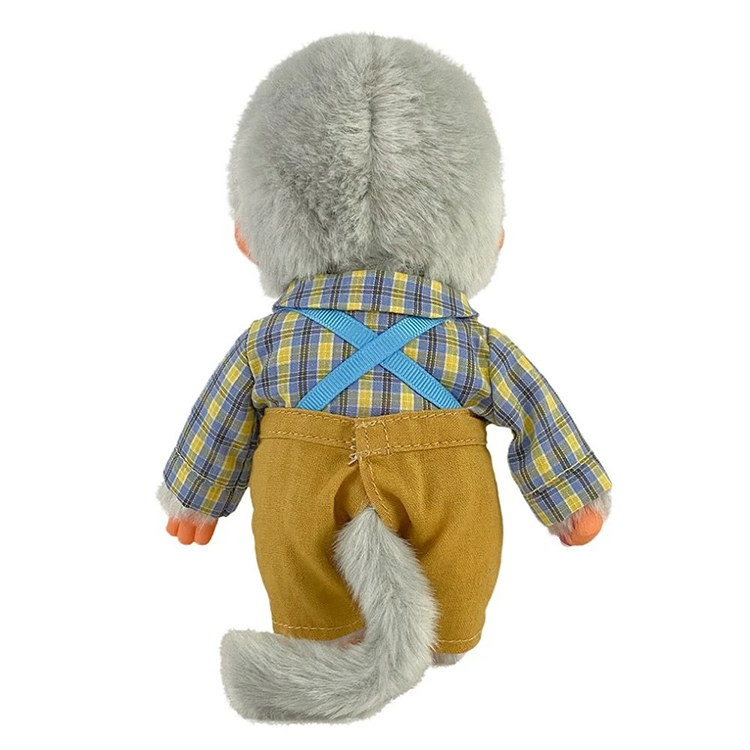 Back view of a Monchhichi doll wearing a plaid shirt and brown pants with blue suspenders and a fluffy gray tail.