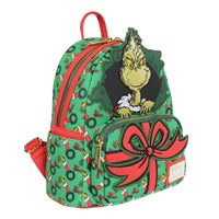 Loungefly mini-backpack with Grinch popping through green wreath pattern and large red bow on front pocket