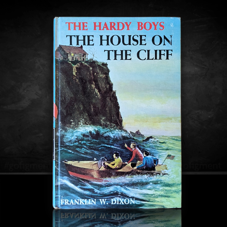 Vintage 1959 edition of The Hardy Boys The House on the Cliff with blue cover and cliffside boat scene by Franklin W. Dixon