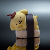 Go Figment collectible featuring yellow dog character with brown beret leaning on white sushi with dark seaweed wrap
