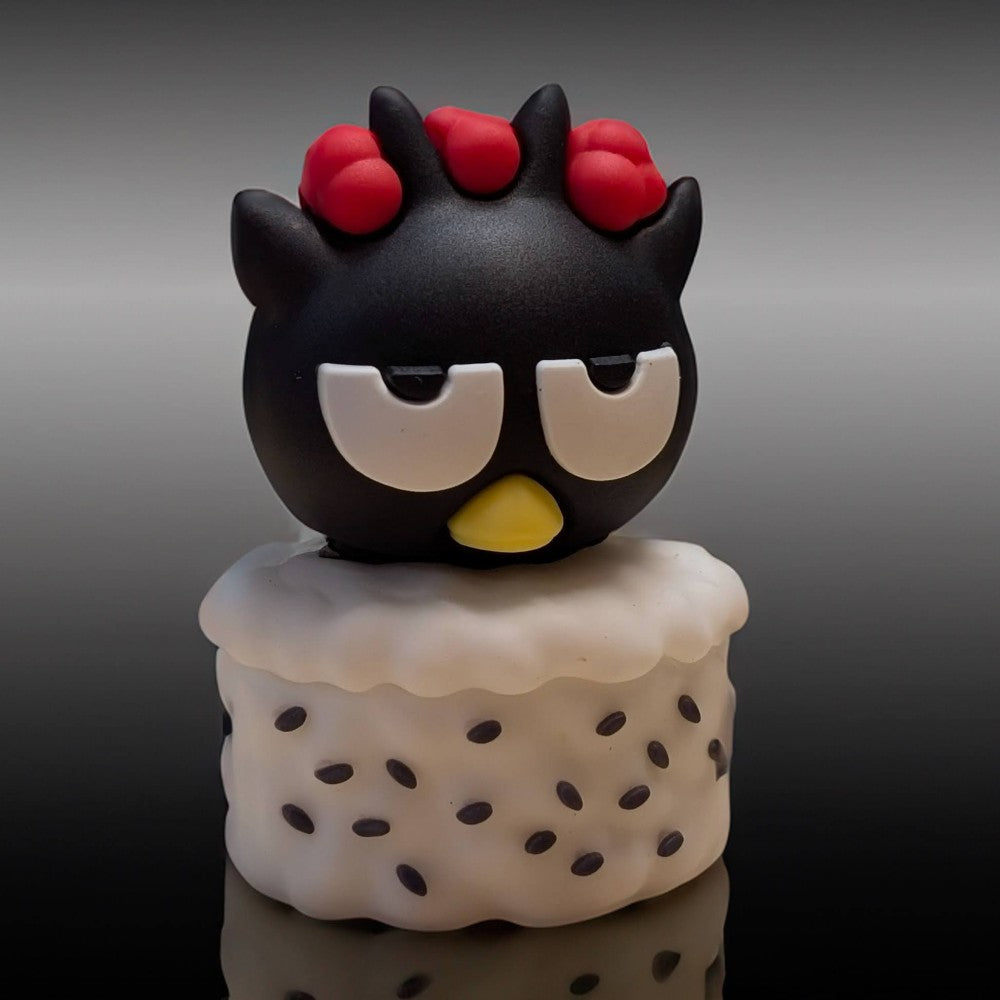 Go Figment figure featuring black character with red bows atop white sushi base sprinkled with black seeds