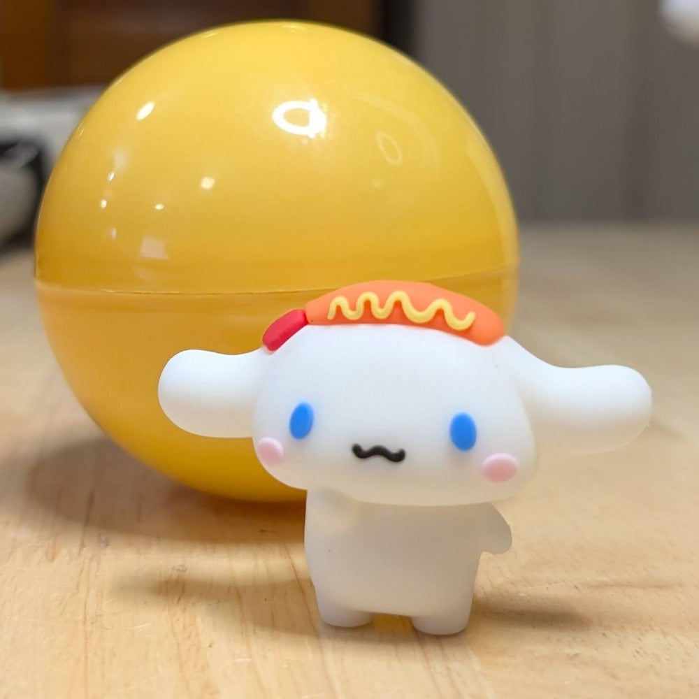 Go Figment collectible featuring white character with blue eyes and sausage detail standing in front of yellow capsule