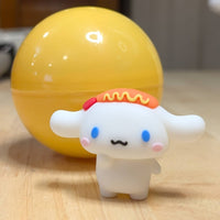 Go Figment collectible featuring white character with blue eyes and sausage detail standing in front of yellow capsule