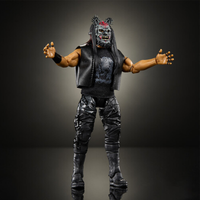 Black-clad action figure with a monster mask, long hair, armored pants, and outstretched arms against a dark background