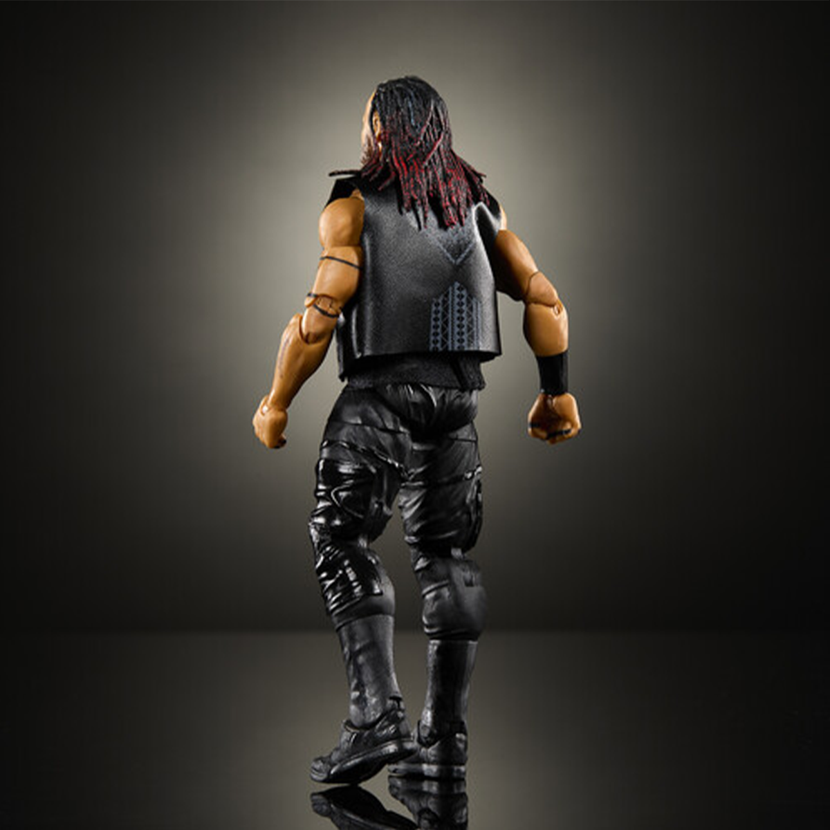 Action figure viewed from behind with dreadlocks wearing a black vest pants and boots