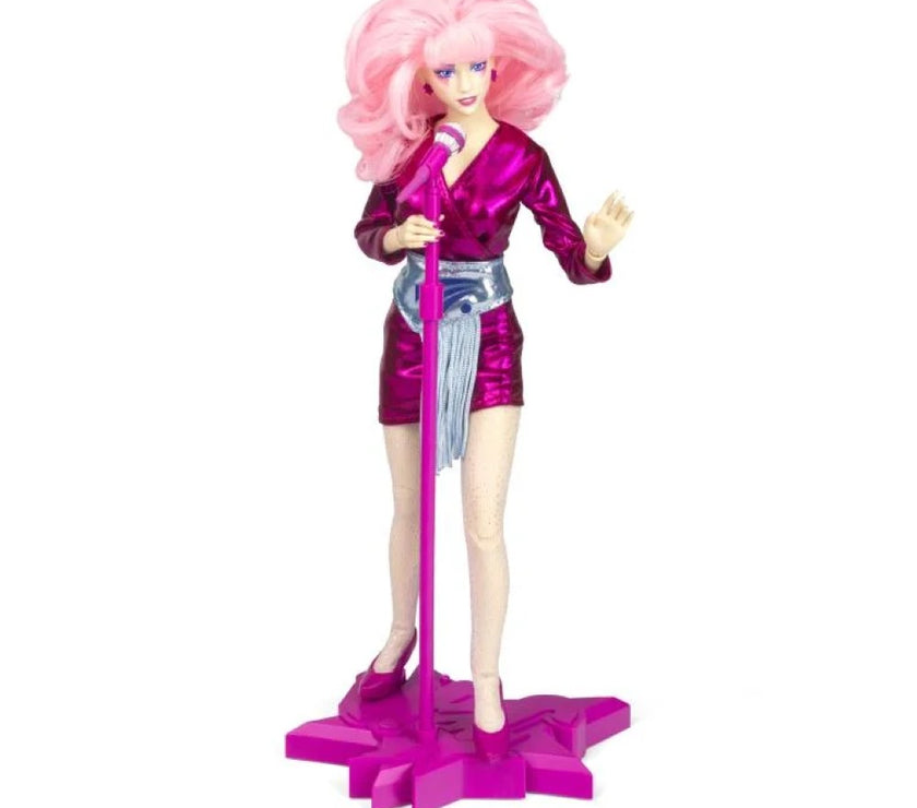 Jem and the Holograms 12 inch fashion doll by Loyal Subjects with pink hair and purple outfit on stage stand