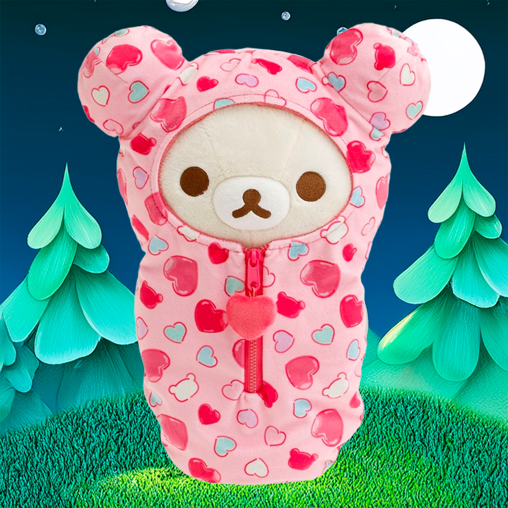 Korilakkuma plush sleeping bag with pink hearts and zipper by San-X against nighttime forest backdrop