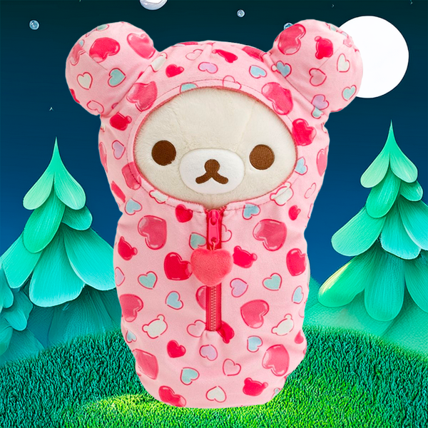 Korilakkuma plush sleeping bag with pink hearts and zipper by San-X against nighttime forest backdrop