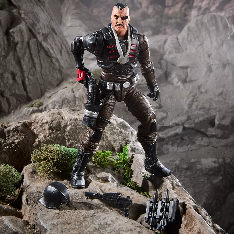 Detailed 6-inch Major Bludd figure by Hasbro in combat pose with weapons and accessories on rocky terrain backdrop