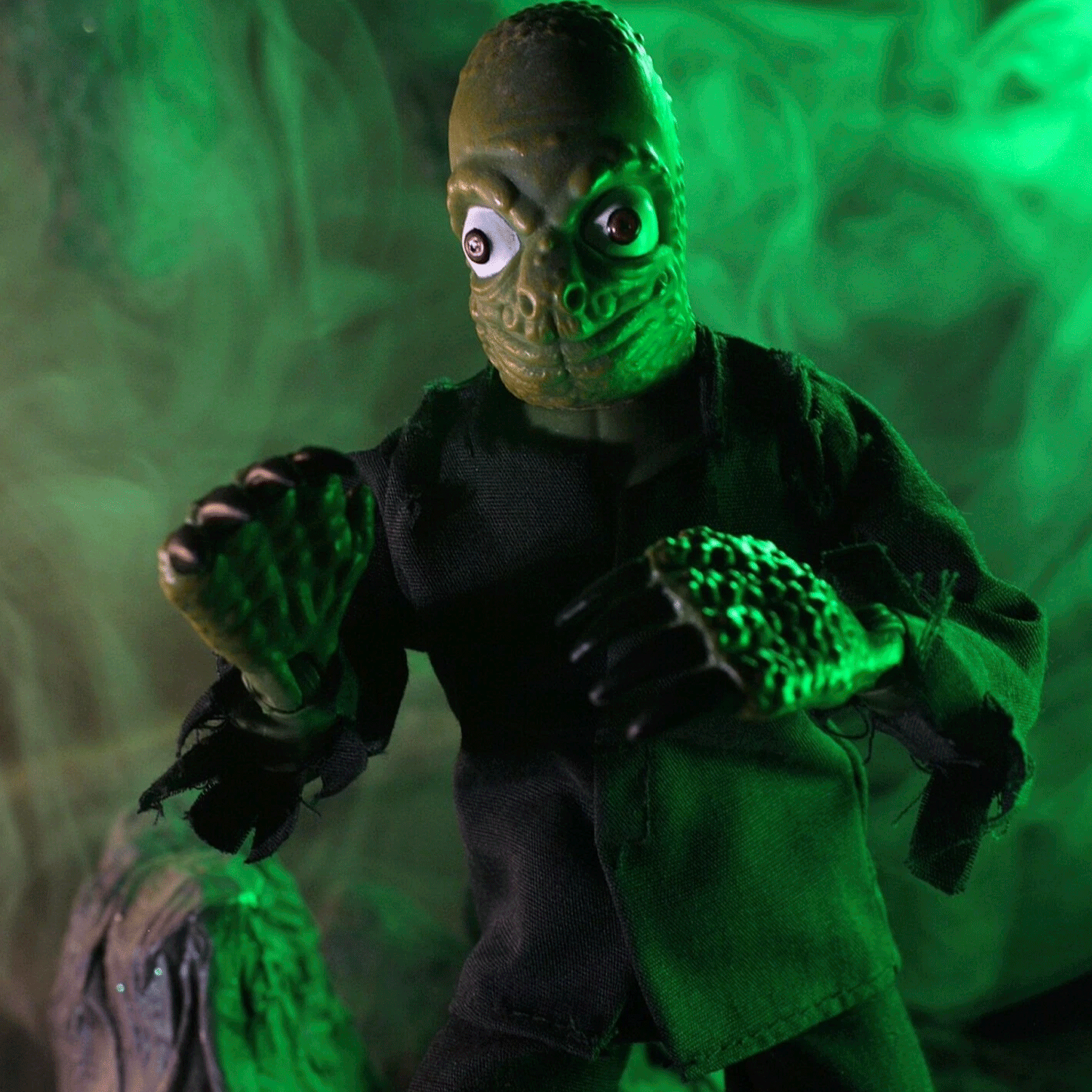Mego 8-inch retro style creature figure with textured green skin and black tattered clothing in eerie green lighting