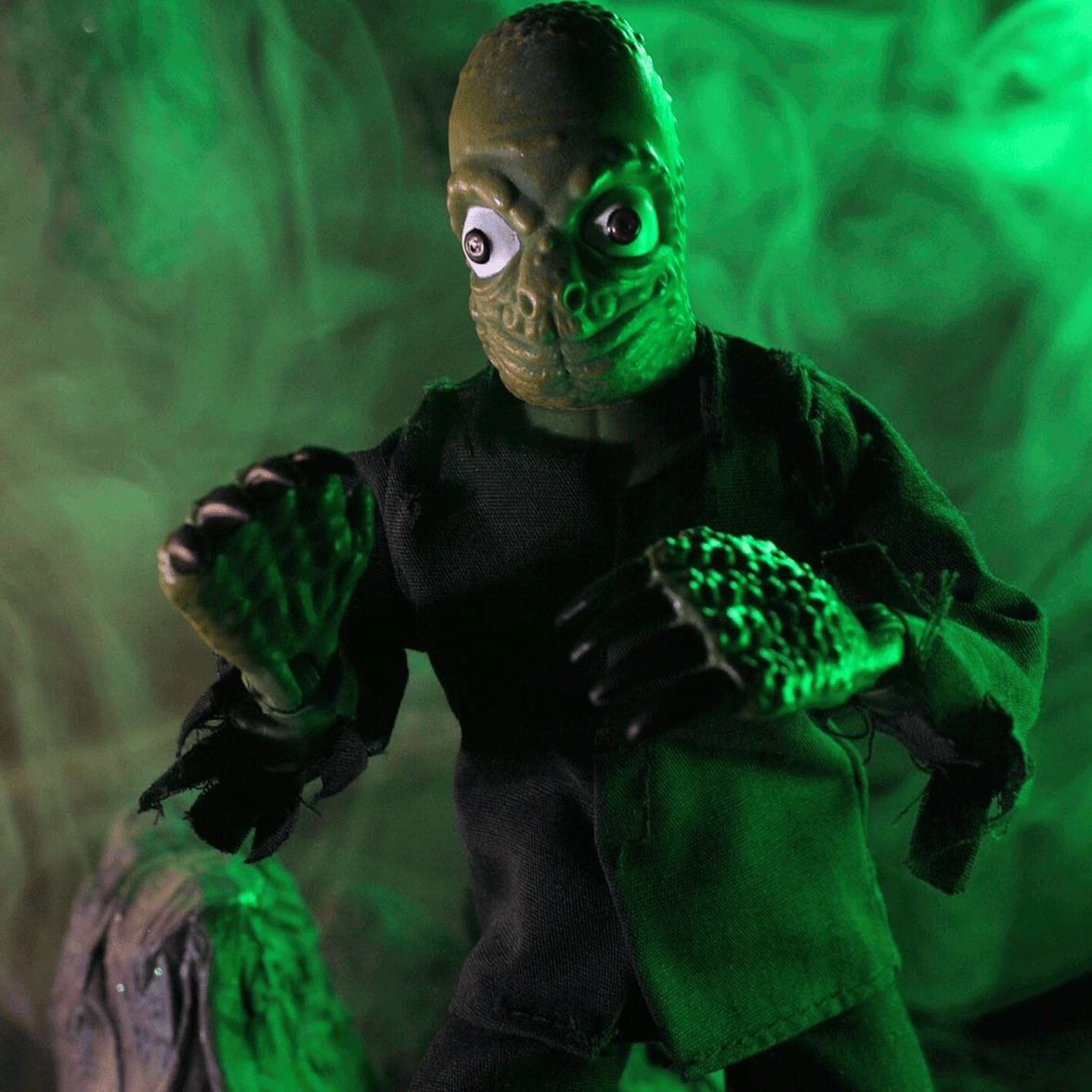 Mego 8-inch retro style creature figure with textured green skin and black tattered clothing in eerie green lighting
