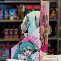 Side profile of 12-inch Hatsune Miku plush with teal hair in UCC platform box featuring chibi Vocaloid characters