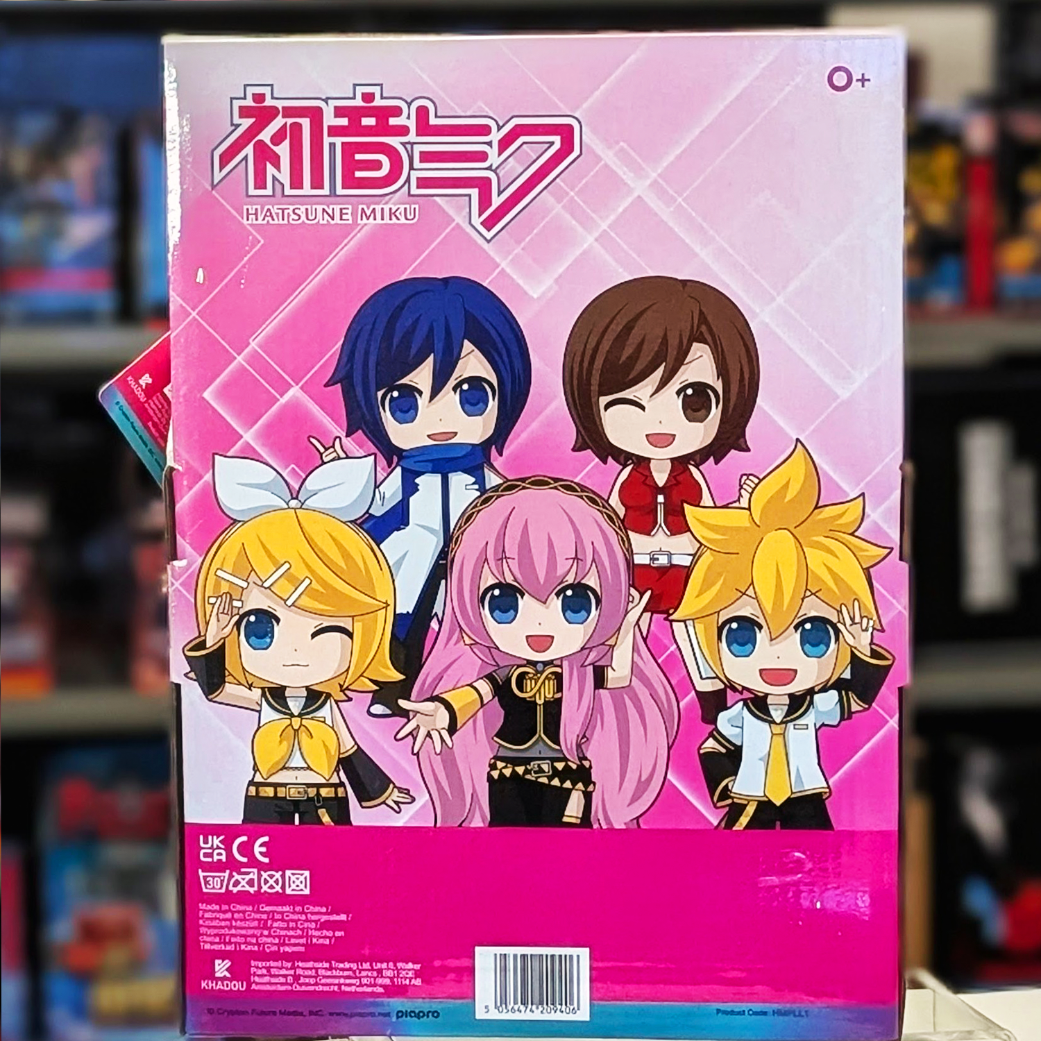 Back of UCC branded pink box featuring colorful chibi Vocaloid characters on a geometric pink background