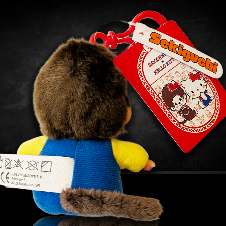 Sekiguchi Monchhichi plush bag clip dressed as Hello Kitty in overalls with red clip and branded tag
