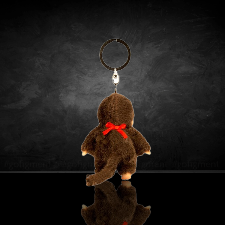 Sekiguchi Monchhichi Classic Boy plush keychain with red bib shown from the back on black background