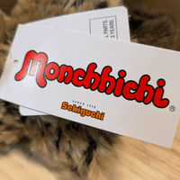 Sekiguchi Monchhichi brand tag on leopard hood and cape plush toy close-up view with clear logo text