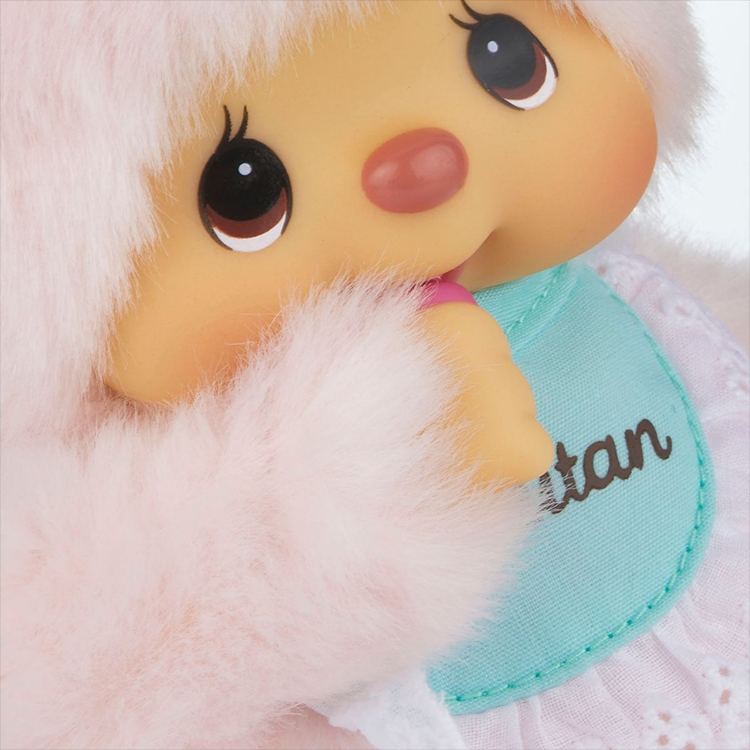 Close-up of Sekiguchi Monchhichi Chimutan Bunny plush with soft pink fur and blue bib thumb in mouth pose