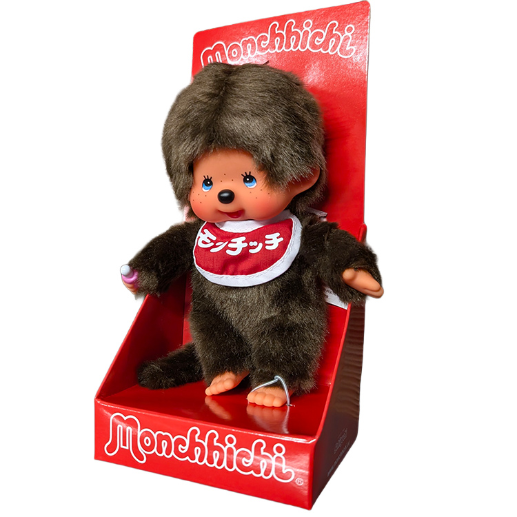 Brown Monchhichi doll with red bib seated in a red display box