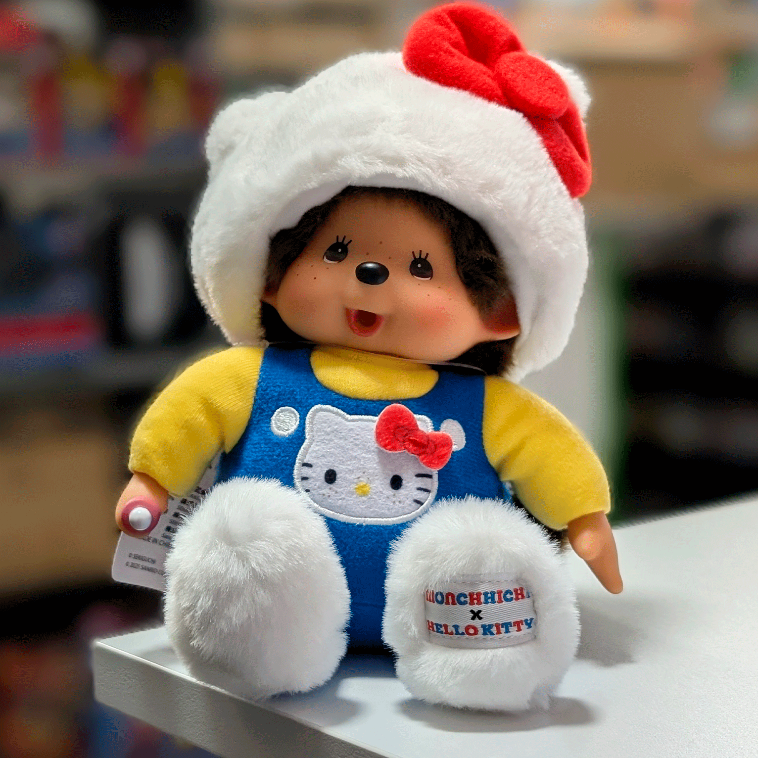 Sekiguchi 8-inch Monchhichi doll dressed as Hello Kitty in overalls with white cat hood and red bow