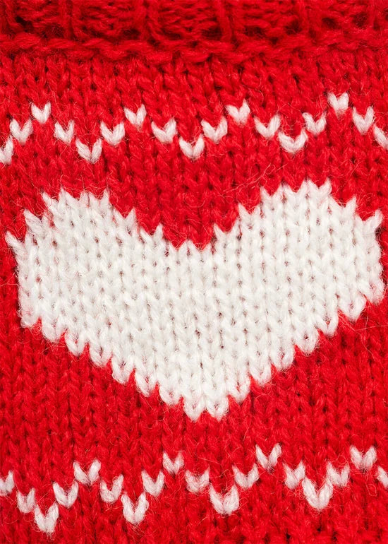 Close-up of a red knitted fabric with a large white heart and zigzag pattern
